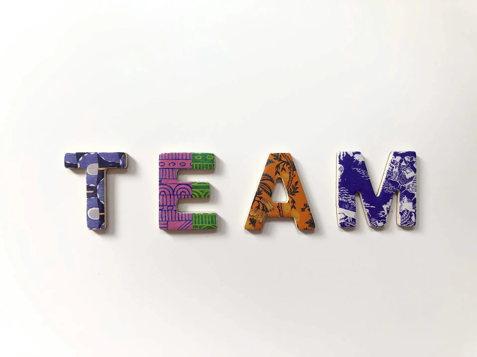 Colorful patterned letters spelling TEAM — the people behind Lenka Studio